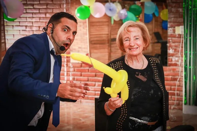 Una señora sorprendida con un globo en un cumpleaños