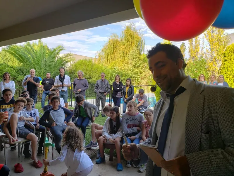 Chicos y grandes mirando el show en un jardín