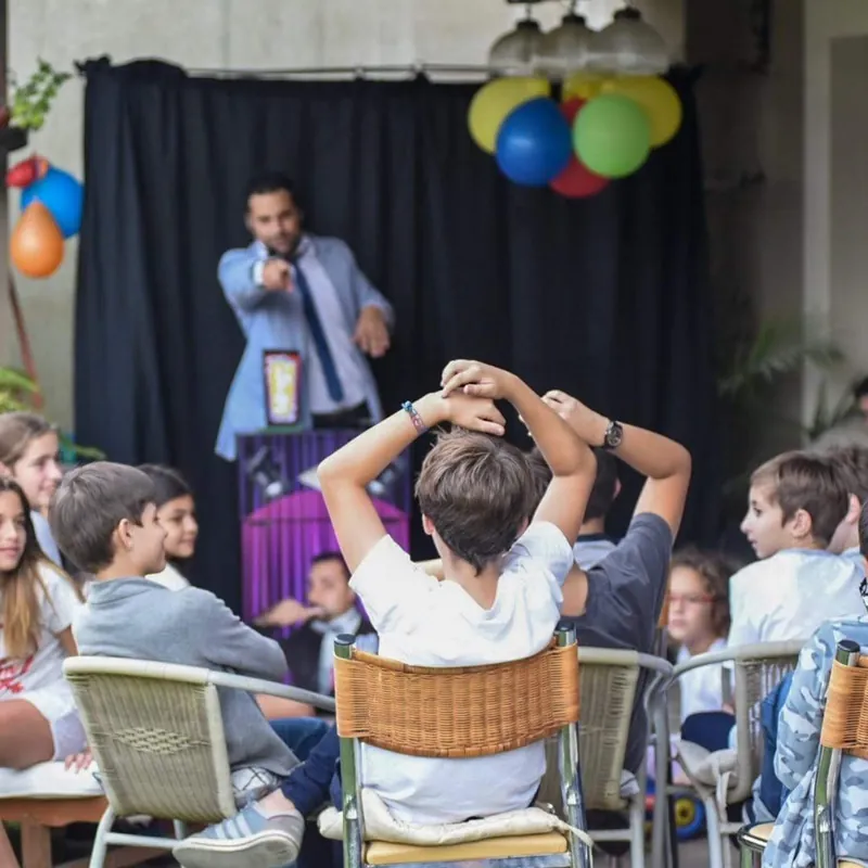 Chicos en sillas con las manos en la cabeza